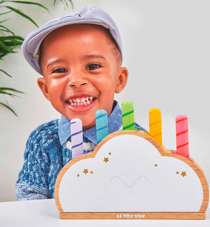 Een houten wolk van Le Toy Van met vijf kleurrijke regenboog pop-up sticks (in drie lengtes) en verborgen veren - spelende jongen