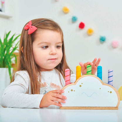 Een houten wolk van Le Toy Van met vijf kleurrijke regenboog pop-up sticks (in drie lengtes) en verborgen veren - spelend meisje